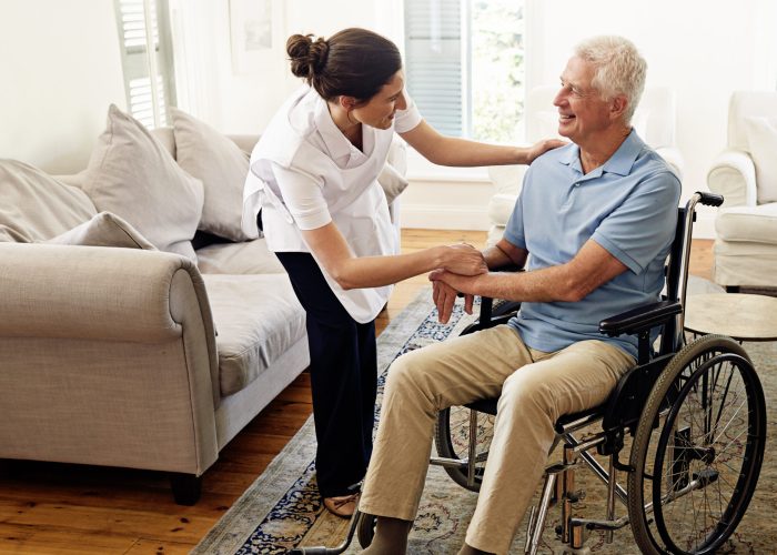 Shot of a caregiver helping a senior man in a wheelchair at home.